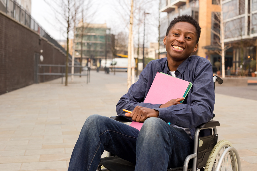 Picture of young man using wheelchair in his college quad