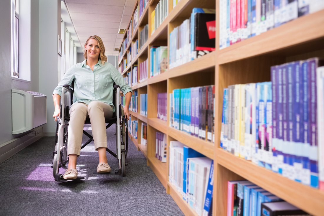Picture of woman in wheelchair by library stacks